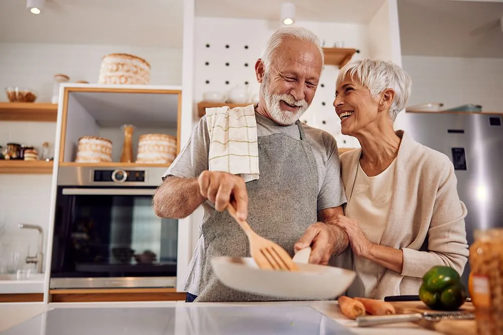 An older couple cooking a meal together at home
