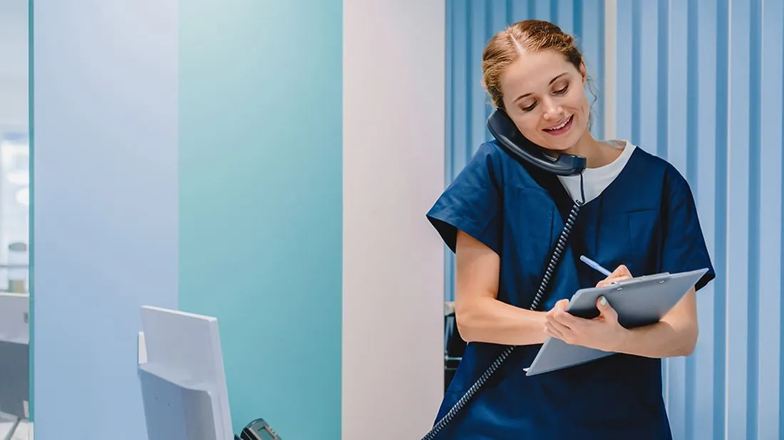 A receptionist taking a call at the front desk